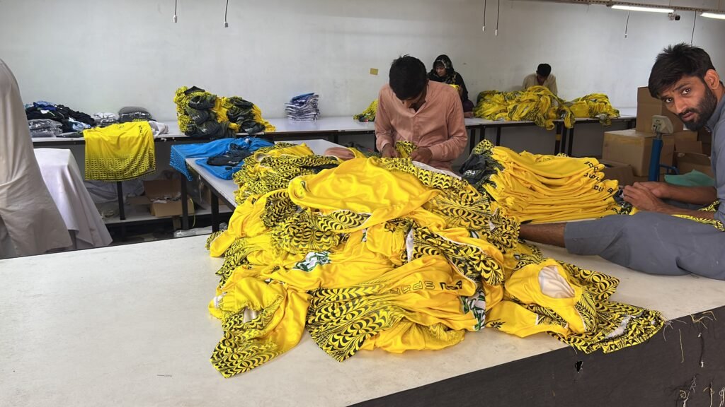 Scarlett Solo Wear factory workers preparing custom sportswear garments on production tables